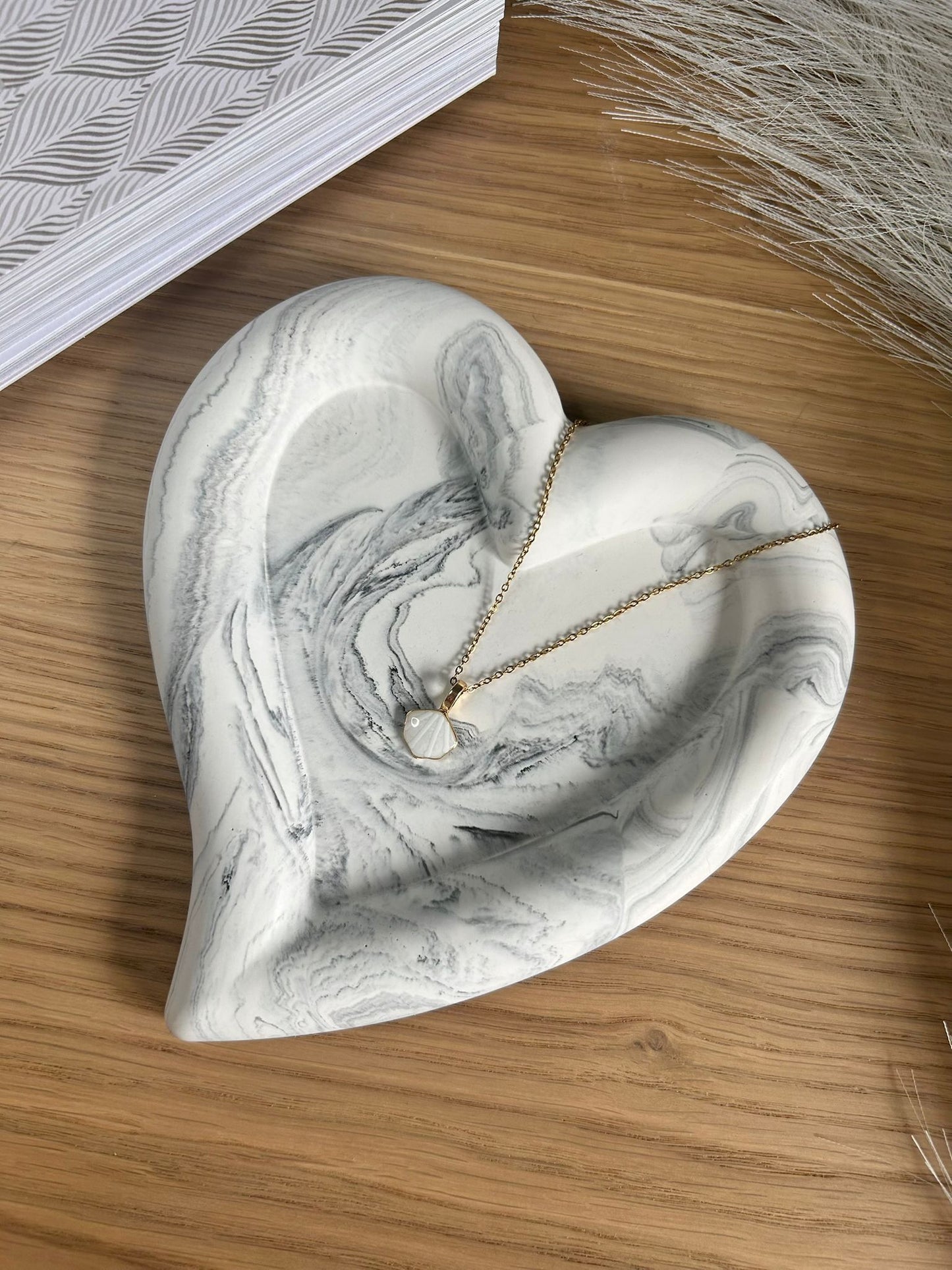 Heart-shaped Jesmonite tray in grey marble, used as a handmade home accessory for jewellery display. Eco-conscious and ideal for minimalist interiors.