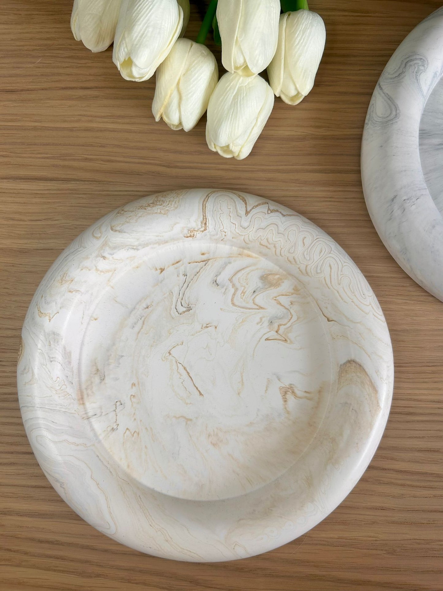 Neutral marble-effect handmade tray styled on wood with ivory tulips – luxury home accessory by Calluna Collection.