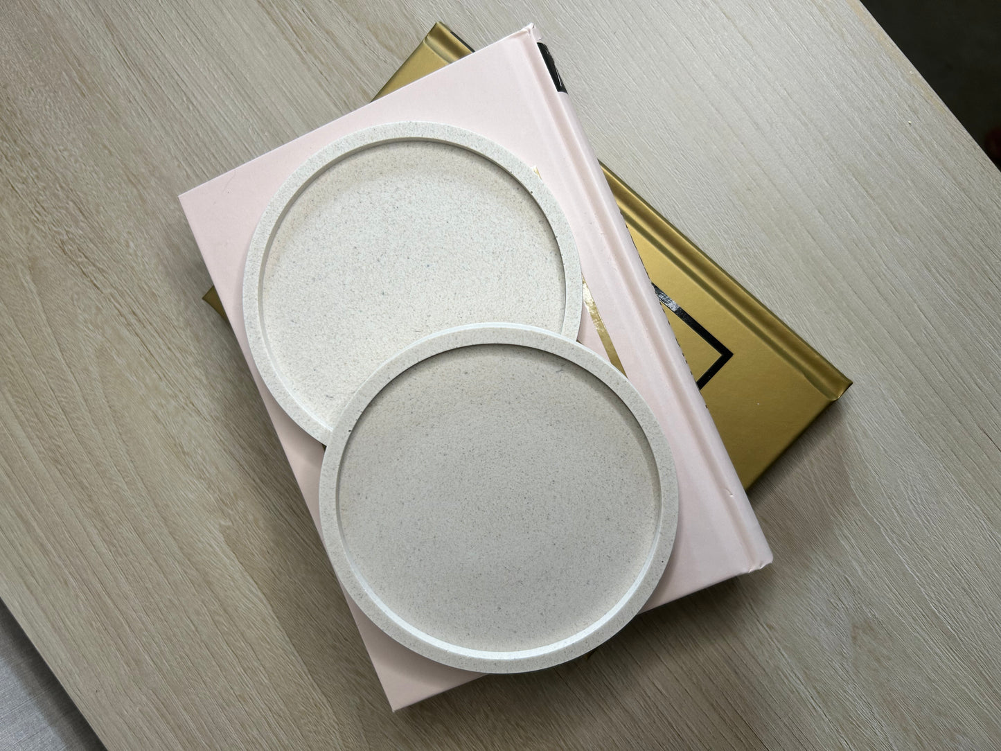 Handmade Home Accessories - A pair of Natural stone coasters taken from a birds eye view, they are stacked on a book.