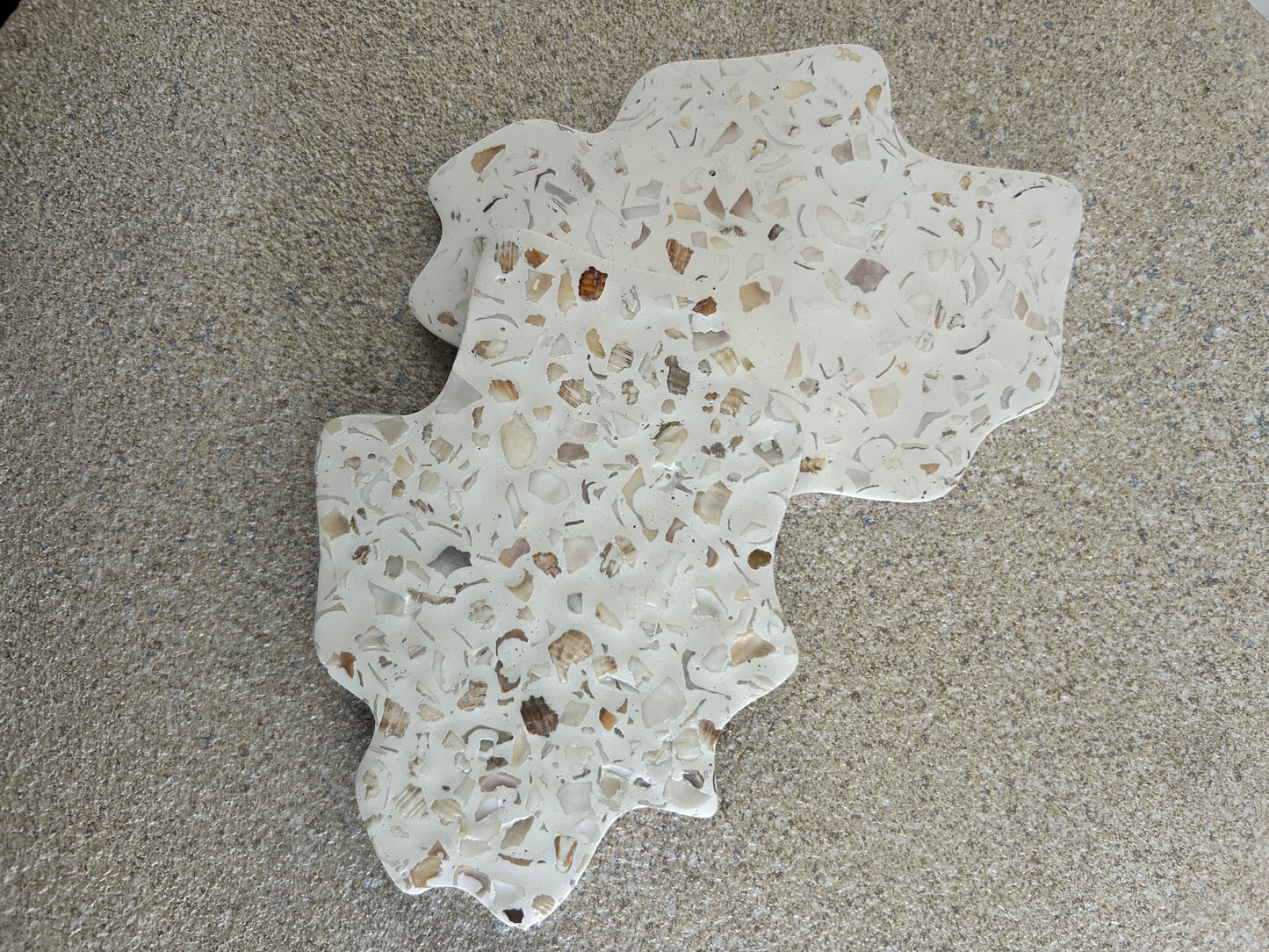 Handmade Home Accessories - A pair of irregular seashell terrazzo coasters on a natural stone background.