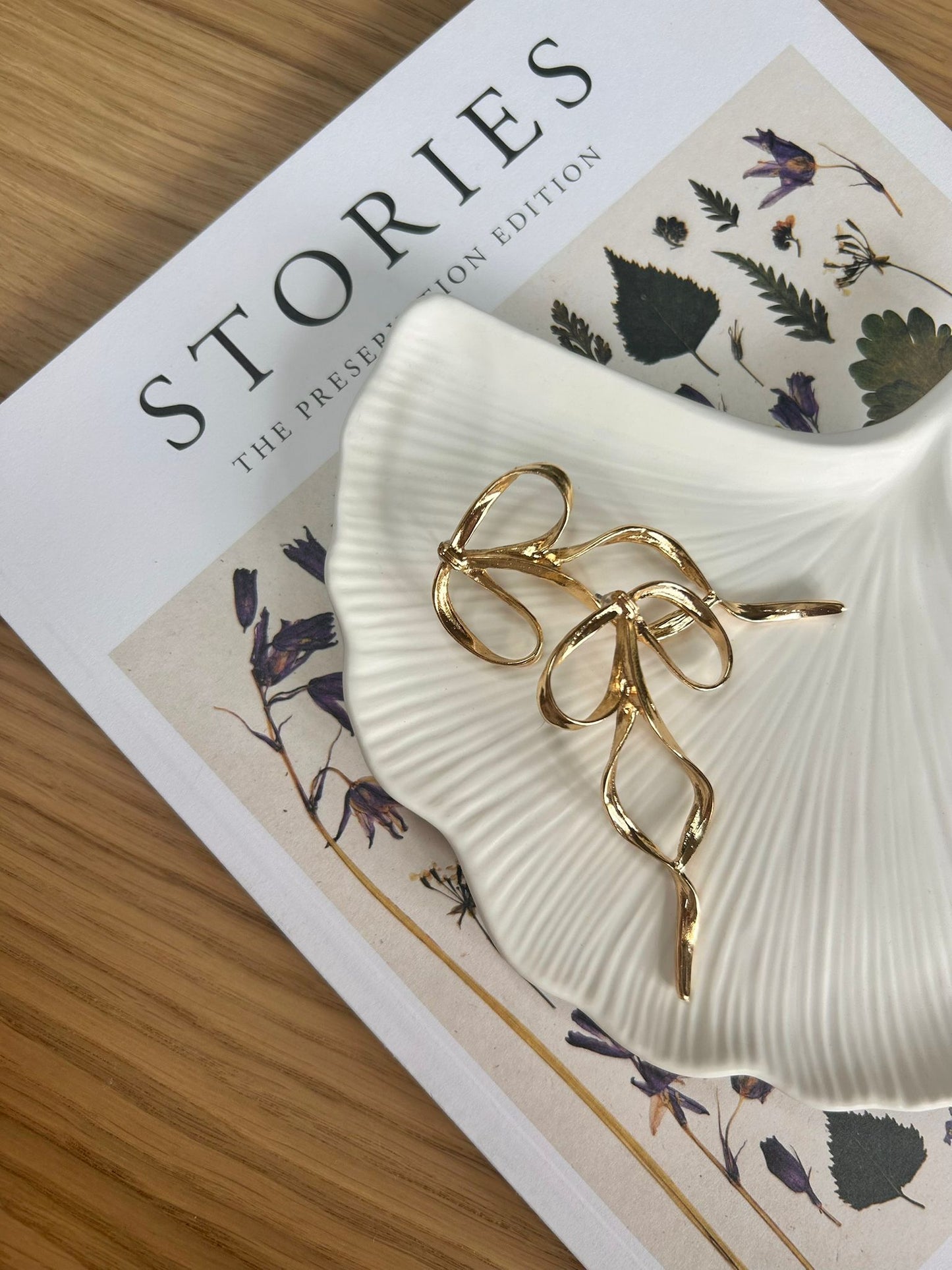 Handmade ginkgo-style tray in soft ceramic, styled with gold jewellery and botanical decor. A sculptural, eco-friendly piece for modern home styling.