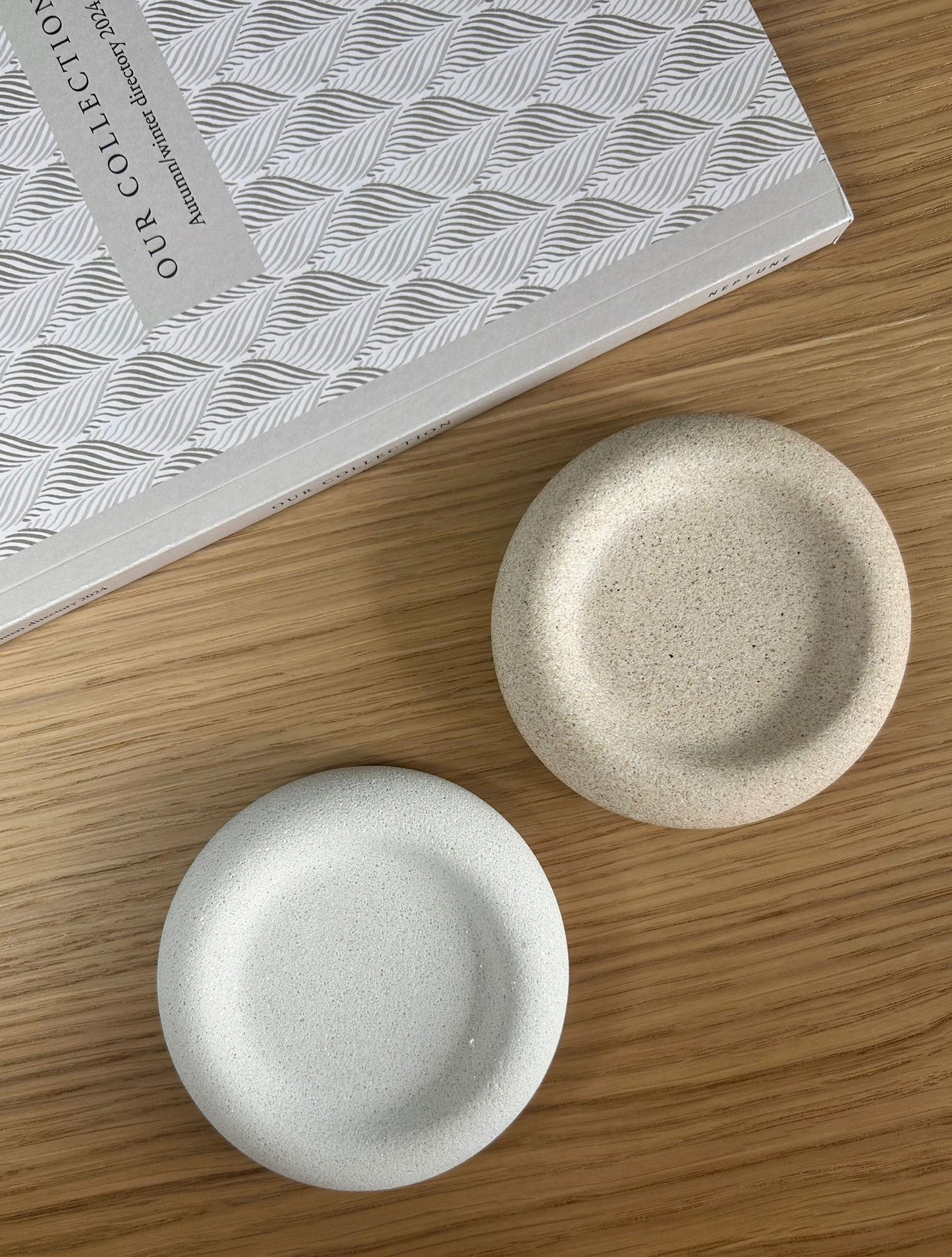 Top-down view of beige and white handmade Jesmonite trays with a raw stone-like finish. Eco-friendly home decor ideal for jewellery or desk styling.