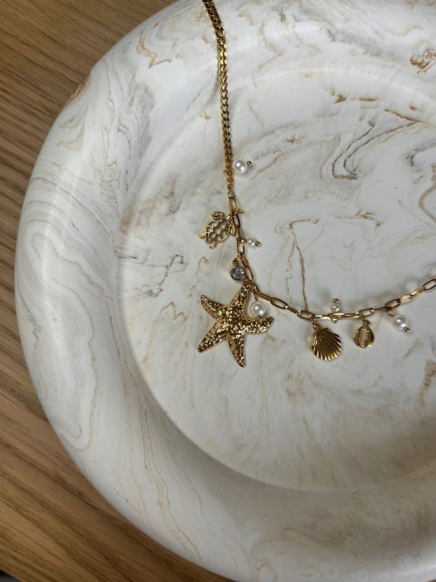 Handmade round tray with gold charm necklace – natural Jesmonite design for dressing tables or gift styling.