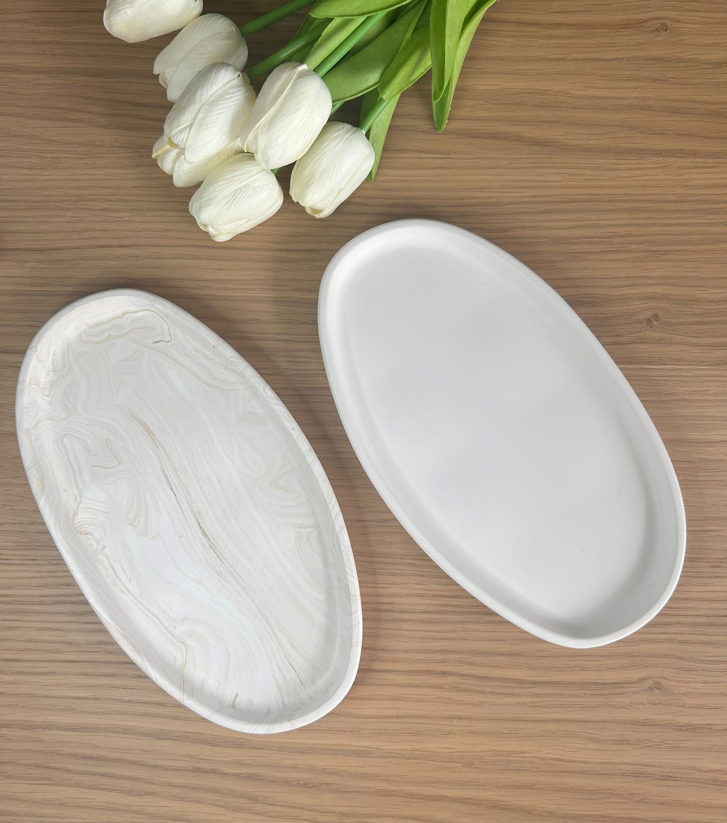 Set of white and marbled oval trinket dishes displayed with tulips, capturing the essence of handmade home accessories for modern interiors.