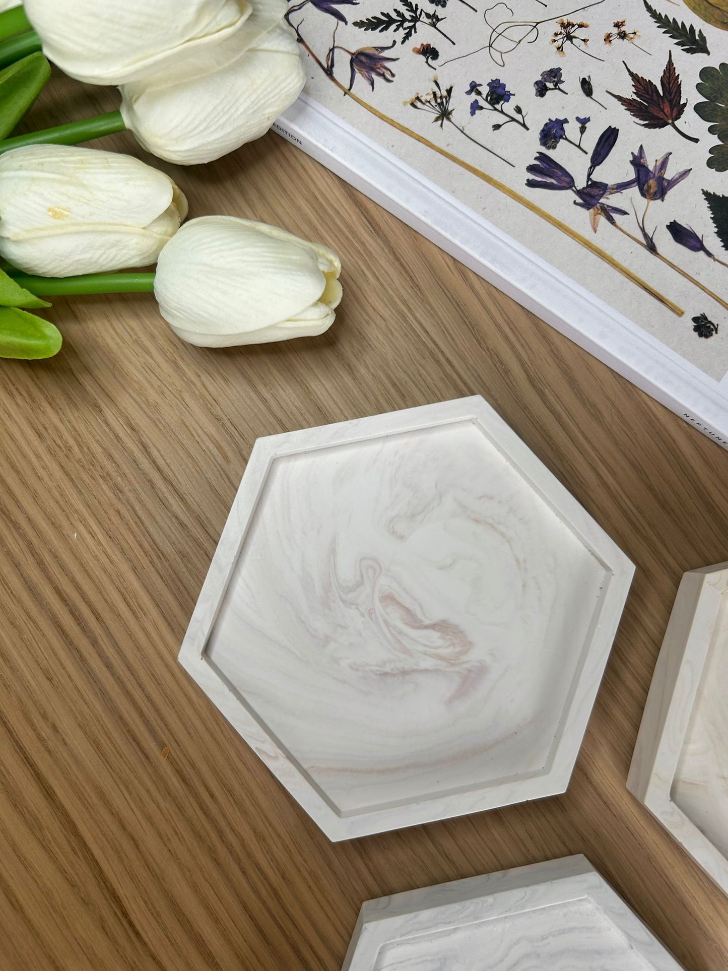 Close-up of a single hexagonal Jesmonite coaster with soft blush marble swirls. A minimalist, sustainable home accessory for jewellery or trinkets.