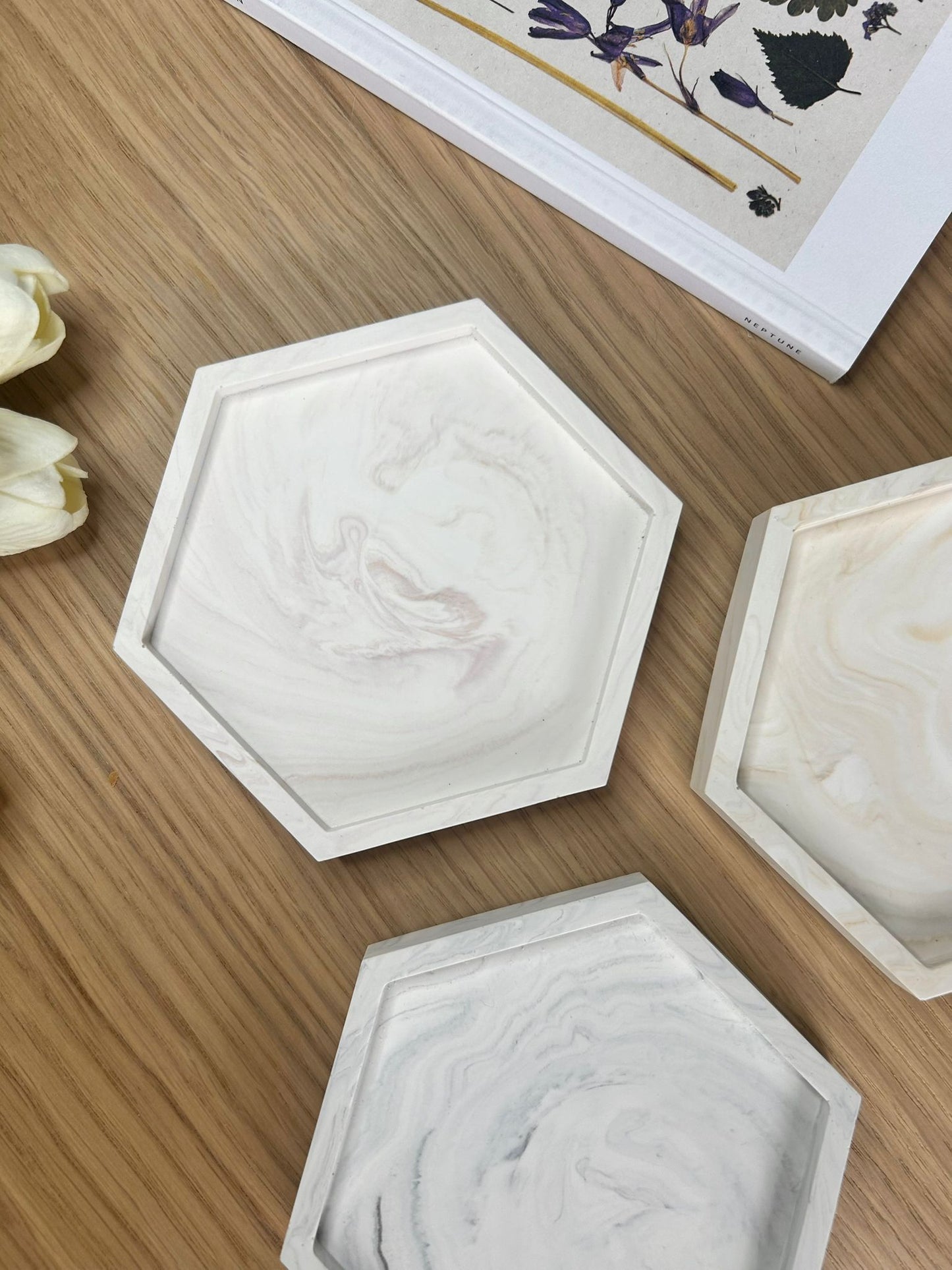 Flat lay of handmade Jesmonite hex trays in rose, cream and grey marbling. Sculptural, eco-friendly home accessories designed for everyday use.