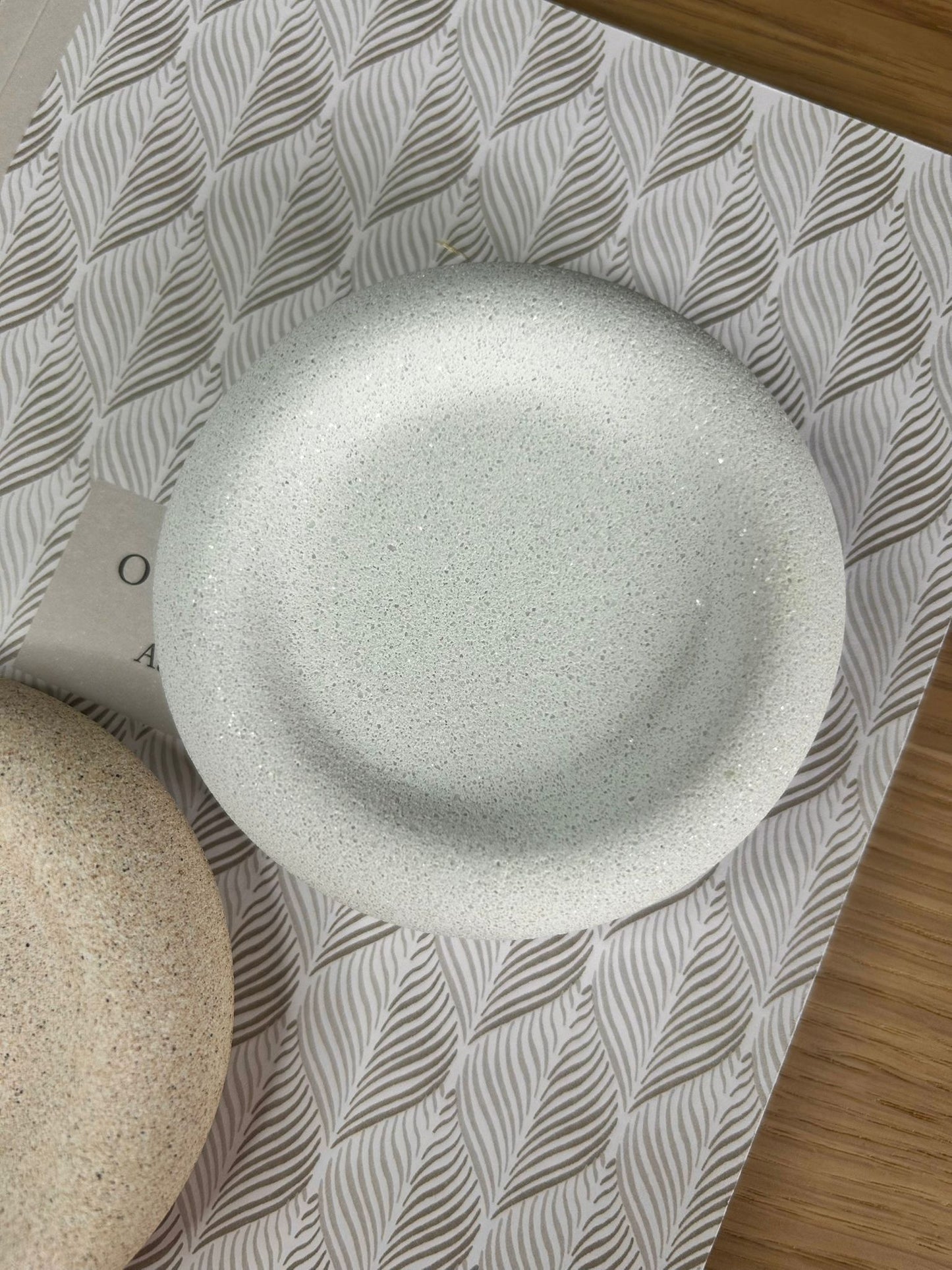 Close-up of a round white marble Jesmonite tray with a smooth, tactile finish. A sustainable handmade home accessory perfect for jewellery, keys, or trinkets.