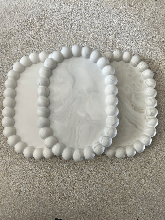 Handmade Home Accessories - Three bubble trinket dishes, one in grey marble, one in greige marble and one pure white stacked together on a stone textured table, with the photo taken from a birds eye view.