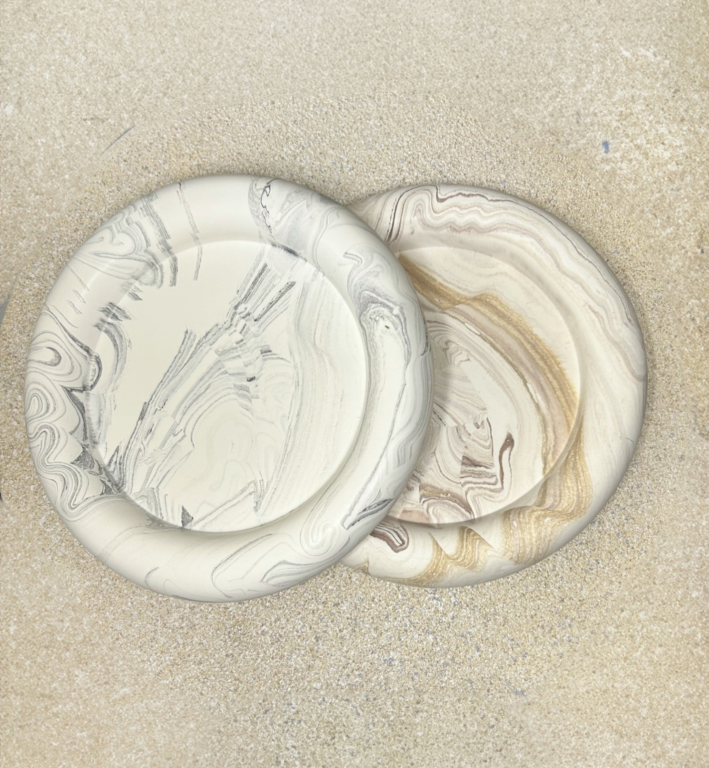 Handmade Home Accessories - Two chunky bowl style trinket trays, one with a grey marble effect and one a brown marble effect on a stone textured background.