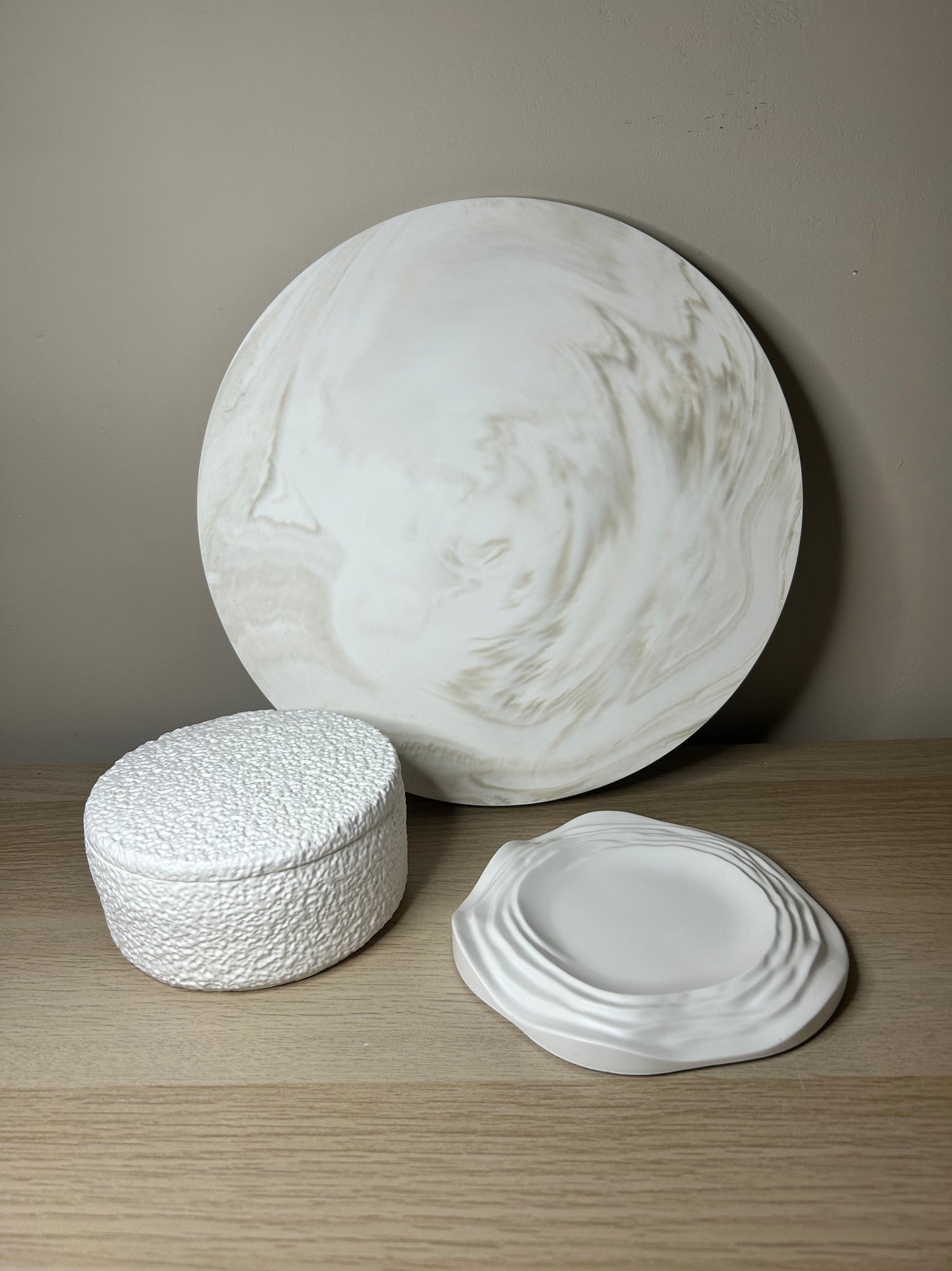 Handmade Home Accessories - a shot of a griege marble display plate with a teddy pot and ripple candle dish by calluna collection on a wooden surface.