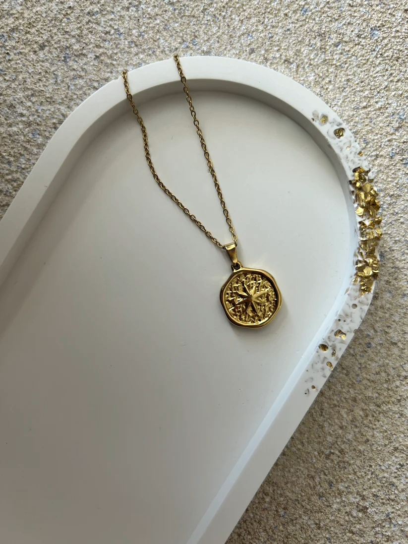 Handmade Home Accessories - A close up shot of a white oval trinket tray with a raw gold druzy edge, with a gold coin style necklace on for display purposes.