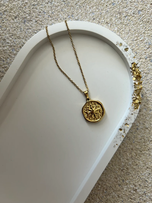 Handmade Home Accessories - A close up shot of a white oval trinket tray with a raw gold druzy edge, with a gold coin style necklace on for display purposes.