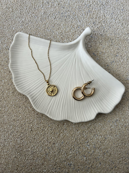 Handmade Home Accessories - A Ginkgo Leaf Trinket tray with a gold pair of hoop earrings and a necklace on. Based on a stone textured table and the photo is taken from Birds eye view.