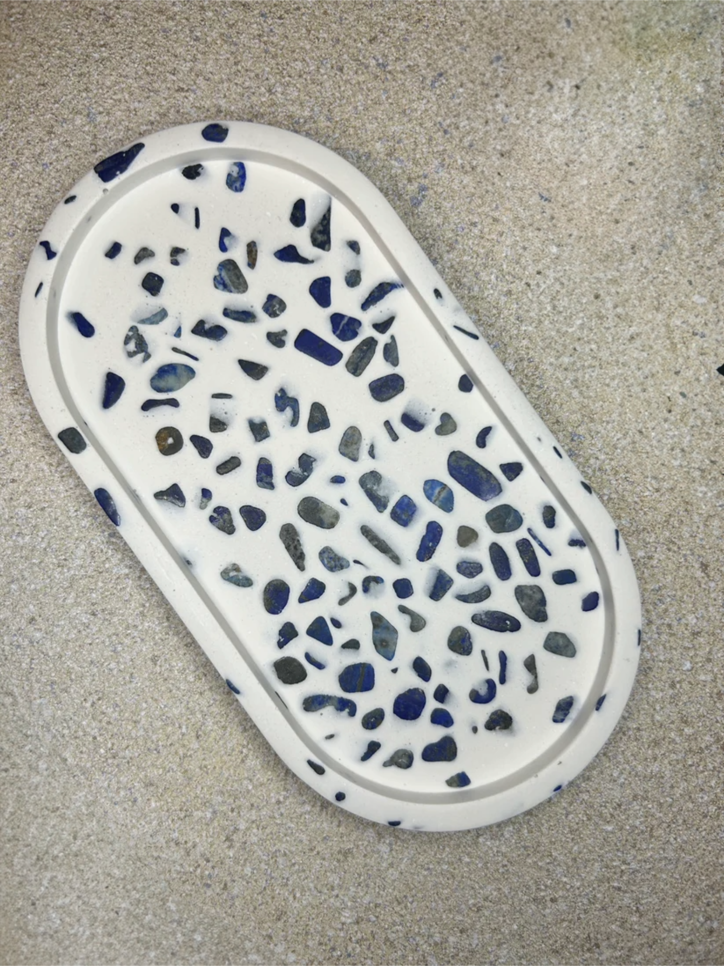 Handmade Home Accessories - a oval shaped blue and white trinket tray at a 45 degree angle on a background of natural stone.