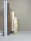 Luna Arch Bookend handcrafted from marbled cream and gold Jesmonite, styled holding neutral-toned design books upright against a minimalist beige backdrop for a serene, sculptural display.