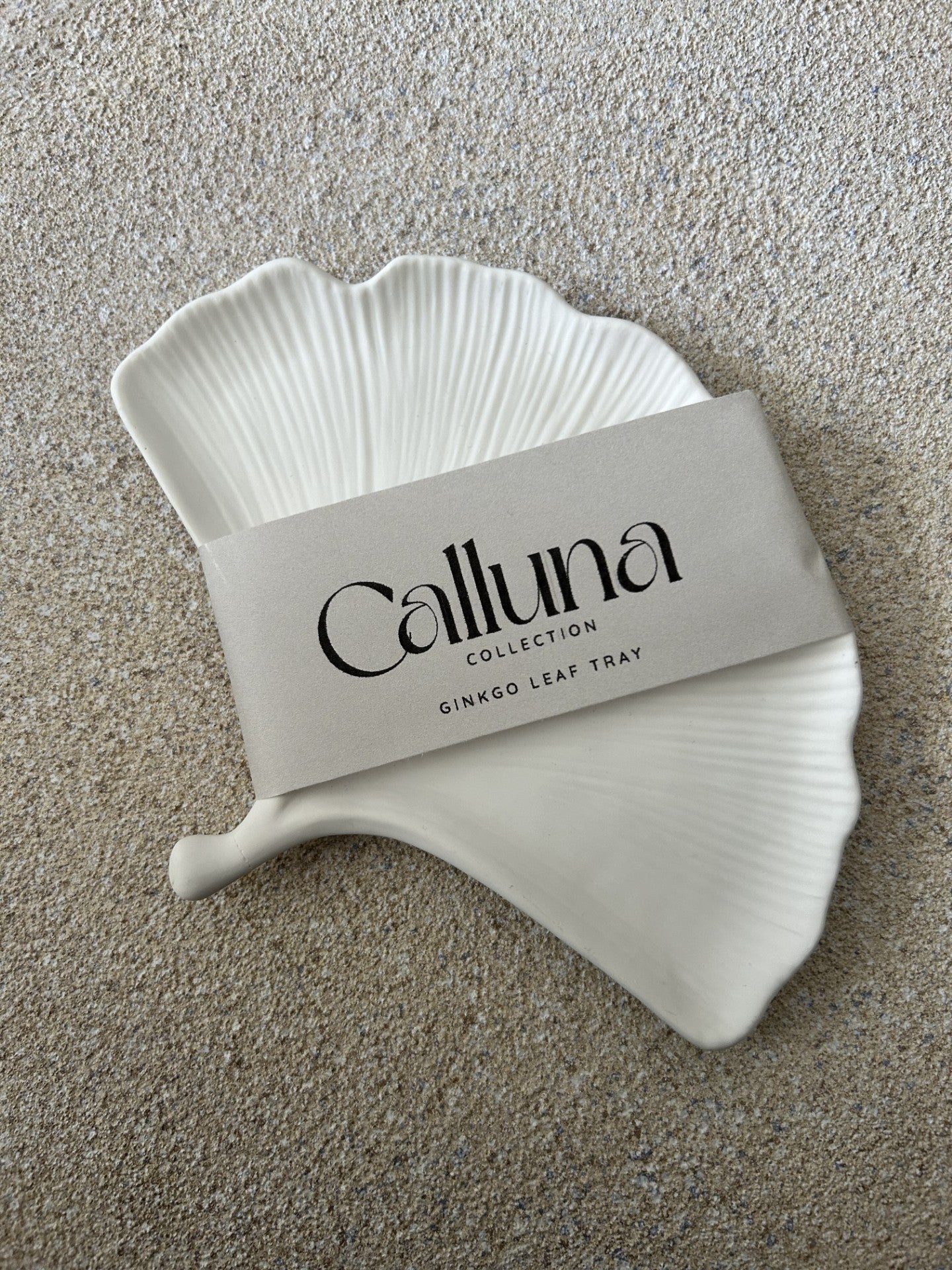 Handmade Home Accessories - A ginkgo leaf trinket tray with a belly band around it that says Calluna Collection, the phto is taken from birds eye view with the intention of showing the customer how the product will be packaged.