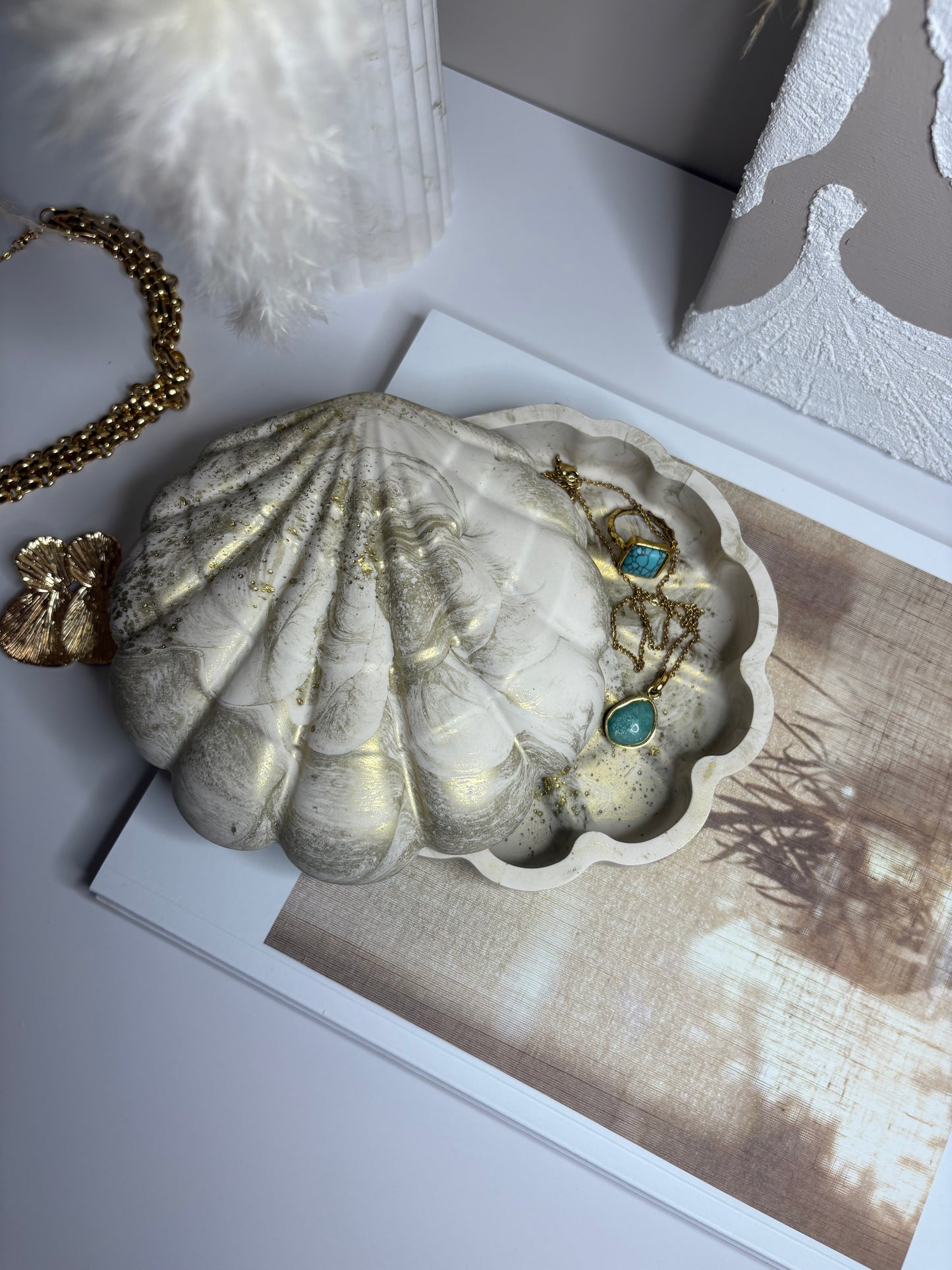 Elegant handmade Jesmonite shell trinket dish with gold marbling, open to display turquoise and gold jewellery, perfect for coastal-inspired home décor and gifting.