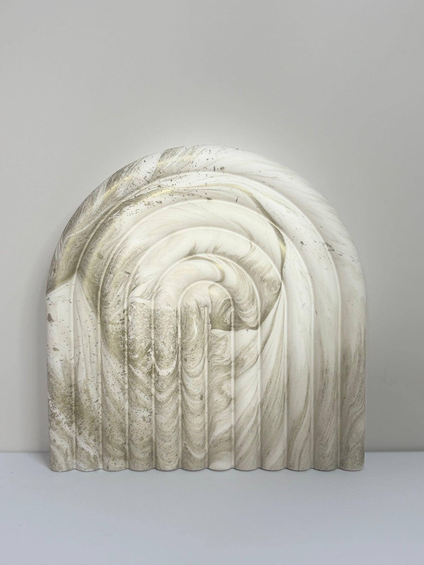 Luna Arch Bookend handcrafted from marbled cream and gold Jesmonite, featuring a sculptural arch design with soft ridged detailing, photographed against a minimalist neutral background for a refined, modern aesthetic.