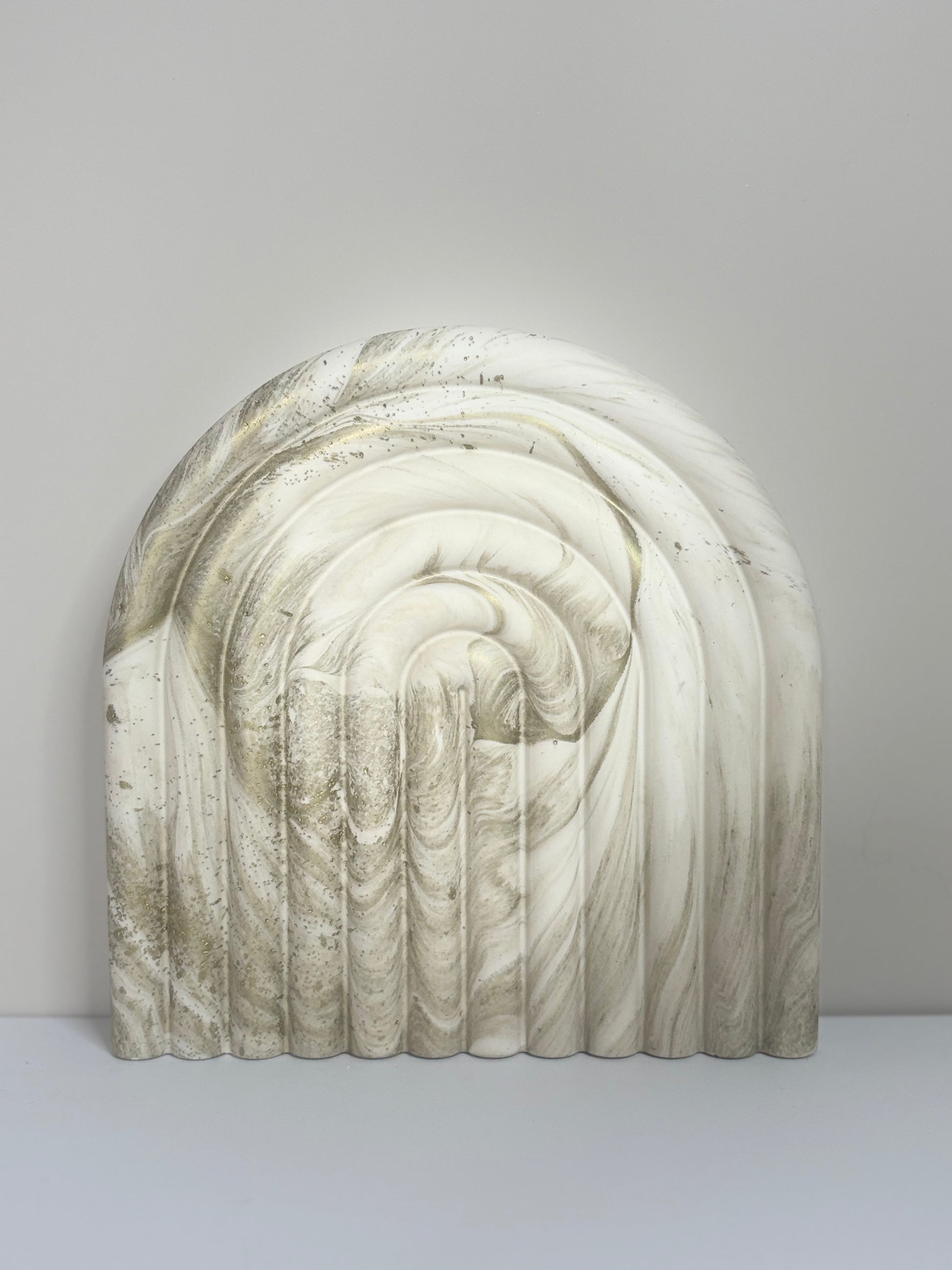 Luna Arch Bookend handcrafted from marbled cream and gold Jesmonite, featuring a sculptural arch design with soft ridged detailing, photographed against a minimalist neutral background for a refined, modern aesthetic.