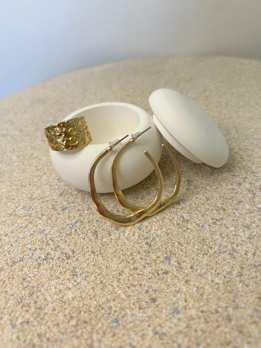 Handmade Home Accessories - a pure white mushroom pot with large gold hoops and a gold ring balanced on it.