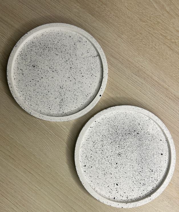 Handmade Home Accessories - two white coasters with black splatters next to each other on a light wooden surface