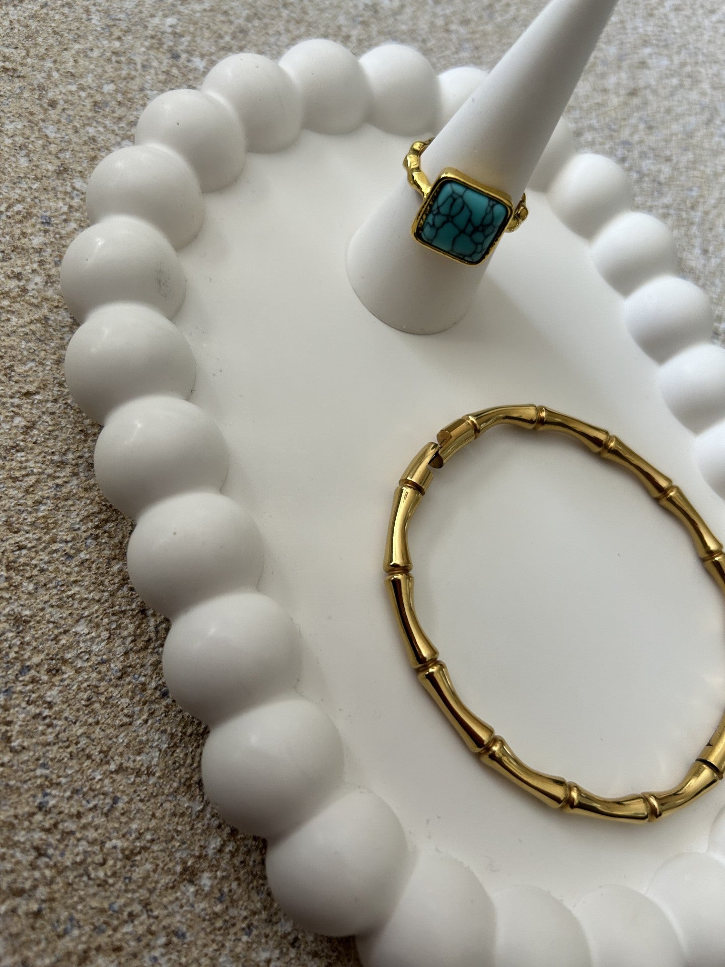 Handmade Home Accessories - White Bubble trinket tray with a white ring holder on, displaying a turquoise gold ring and a wishbone gold bracelet. it is an angled close up shot.