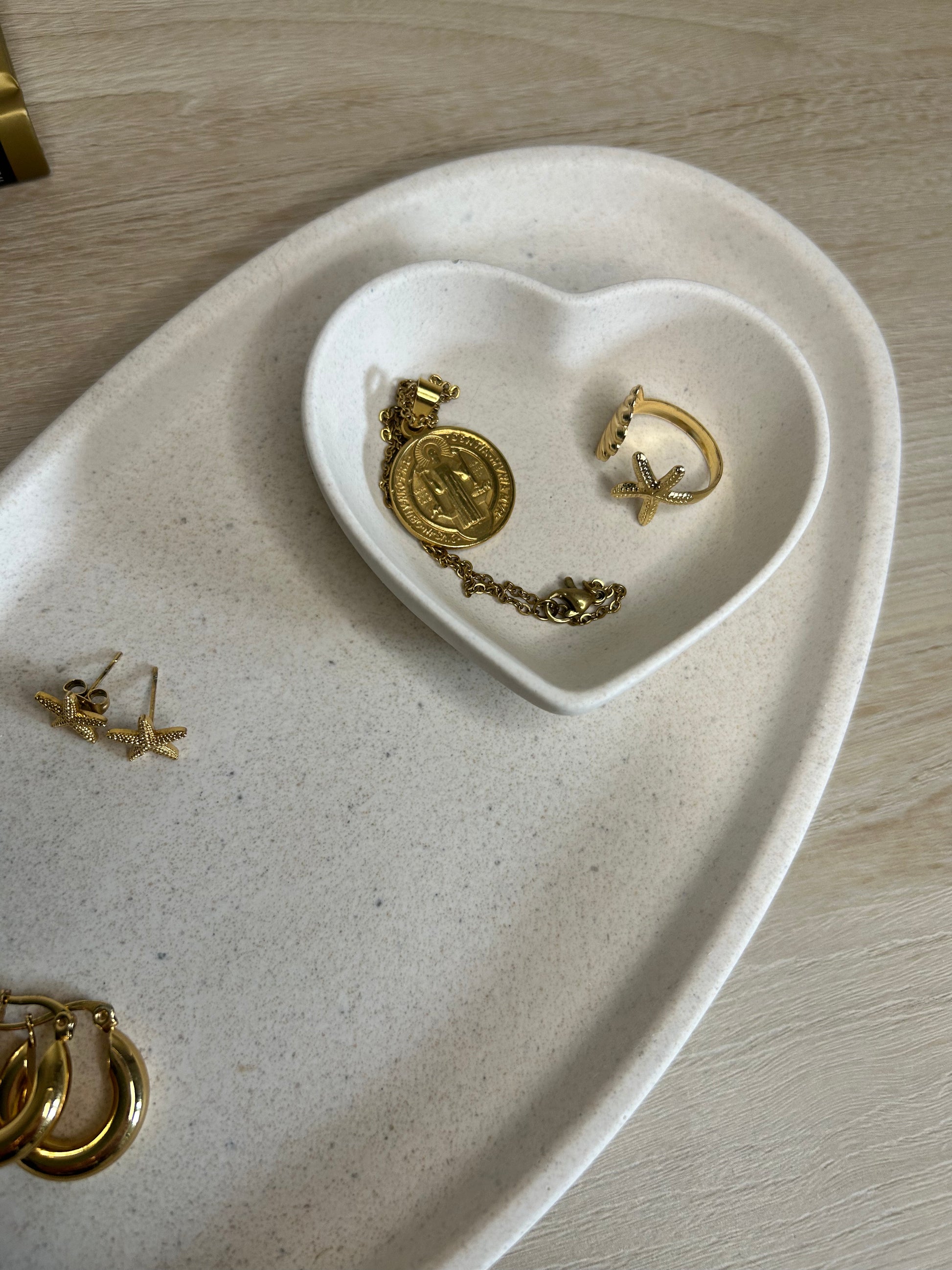 Handmade Home Accessories - A close up shot of the curve tray with a heart dish displayed on top holding gold jewellery.