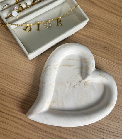 Handmade home accessory – heart-shaped Jesmonite tray with warm cream marbling, styled with a gold Dior bracelet. A minimalist jewellery dish crafted sustainably.