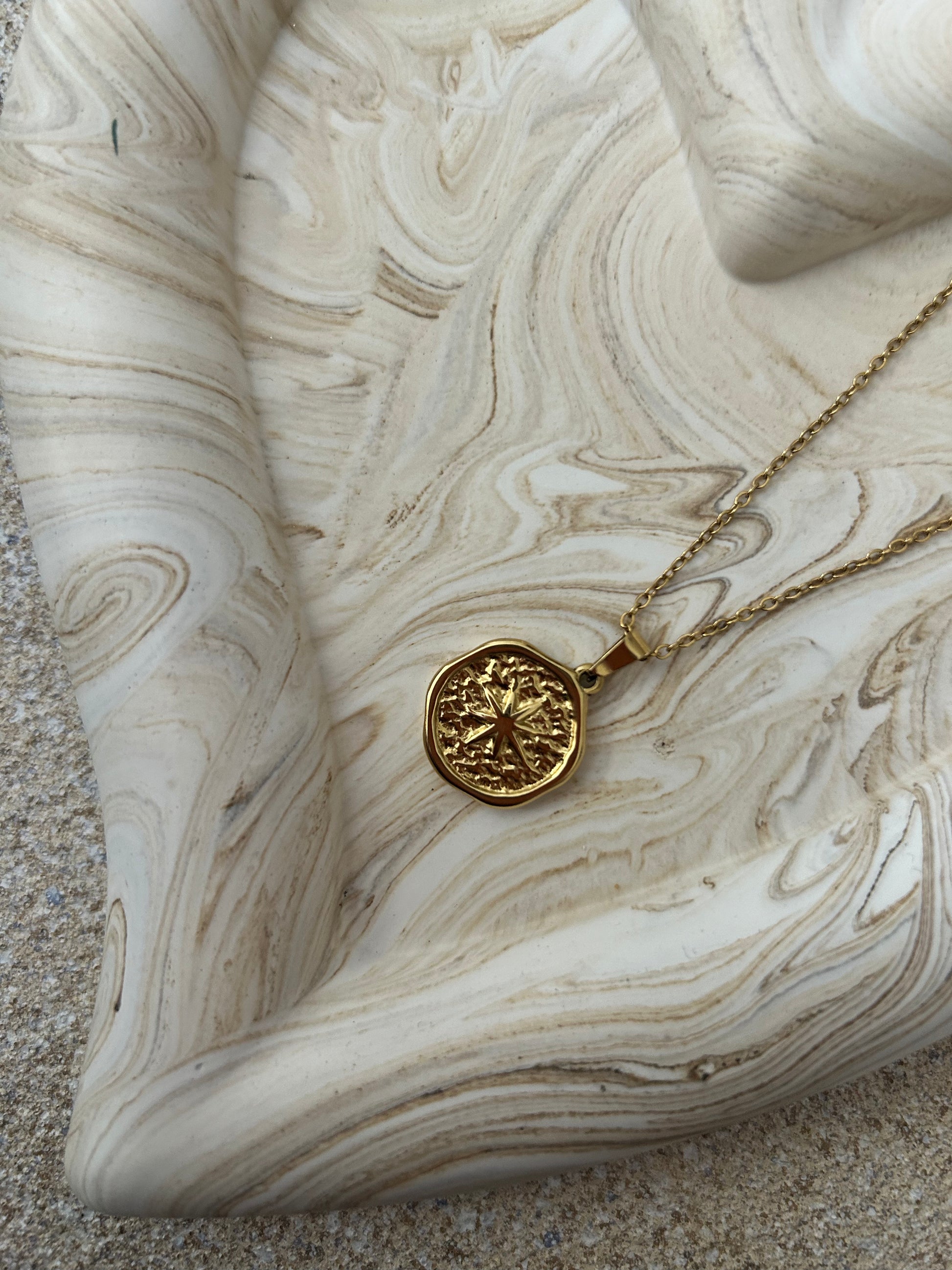 Handmade Home Accessories - A close up shot of a brown marble heart trinket tray showing its chunky edges, it has a gold star coin necklace on it for display purposes.