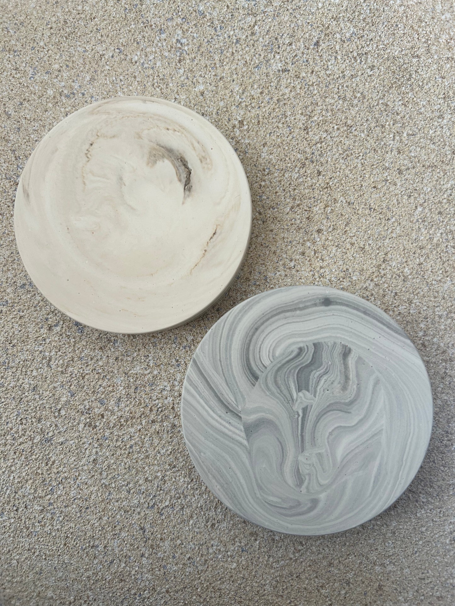 Handmade Home Accessories - a pair of chunky thick coasters, one in grey marble and one in beige marble.