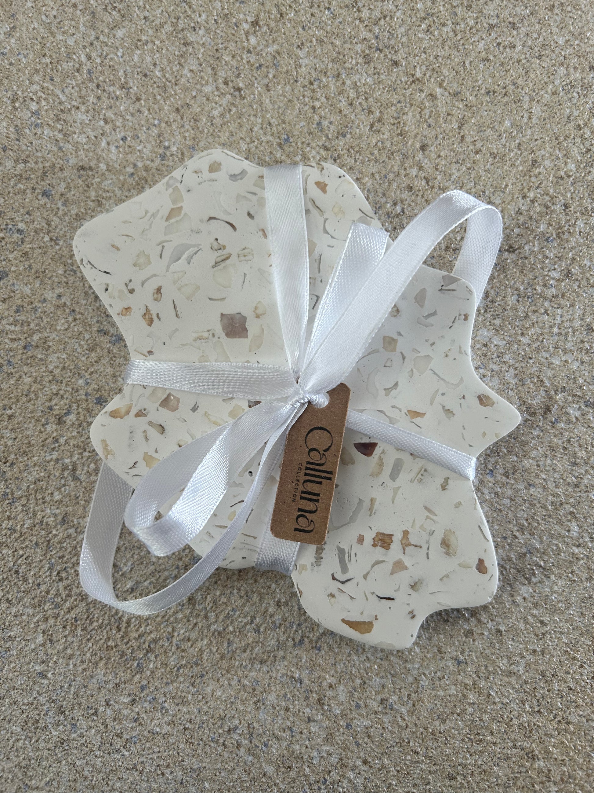 Handmade Home Accessories - A irregular seashell coaster in white with a white bw around, with a tag that states Calluna Collection.