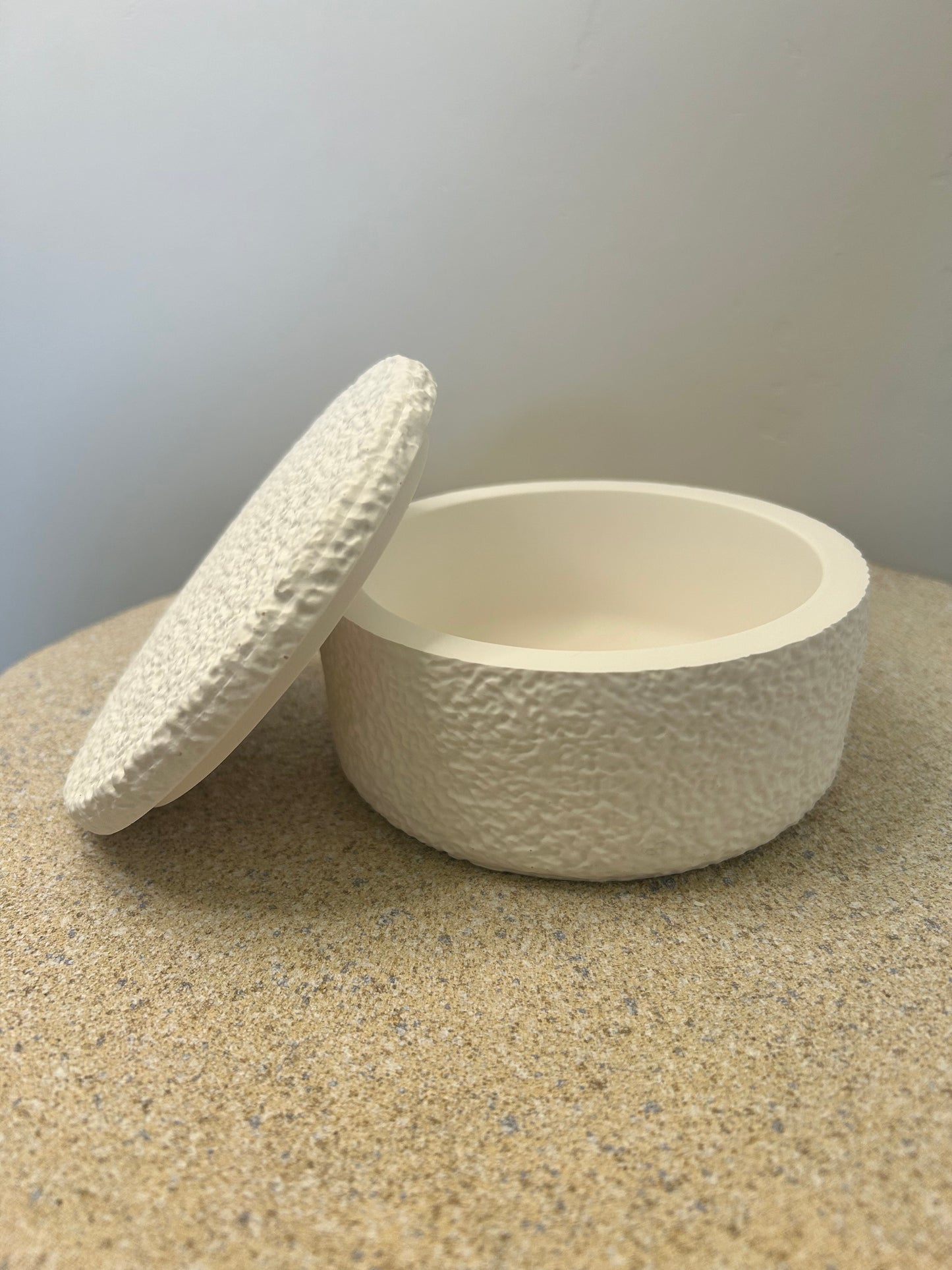 Handmade Home Accessories - A white pot with a textured design on a natural stone base