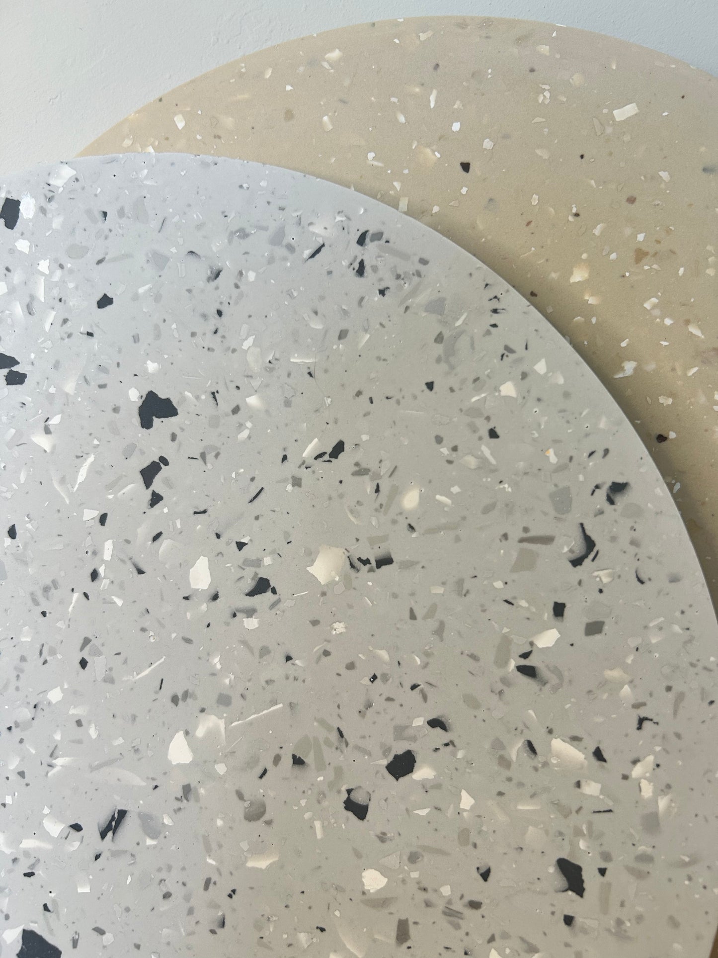 Handmade Home Accessories - a close up shot showing a grey terrazzo design with a beige terrazzo design int the background