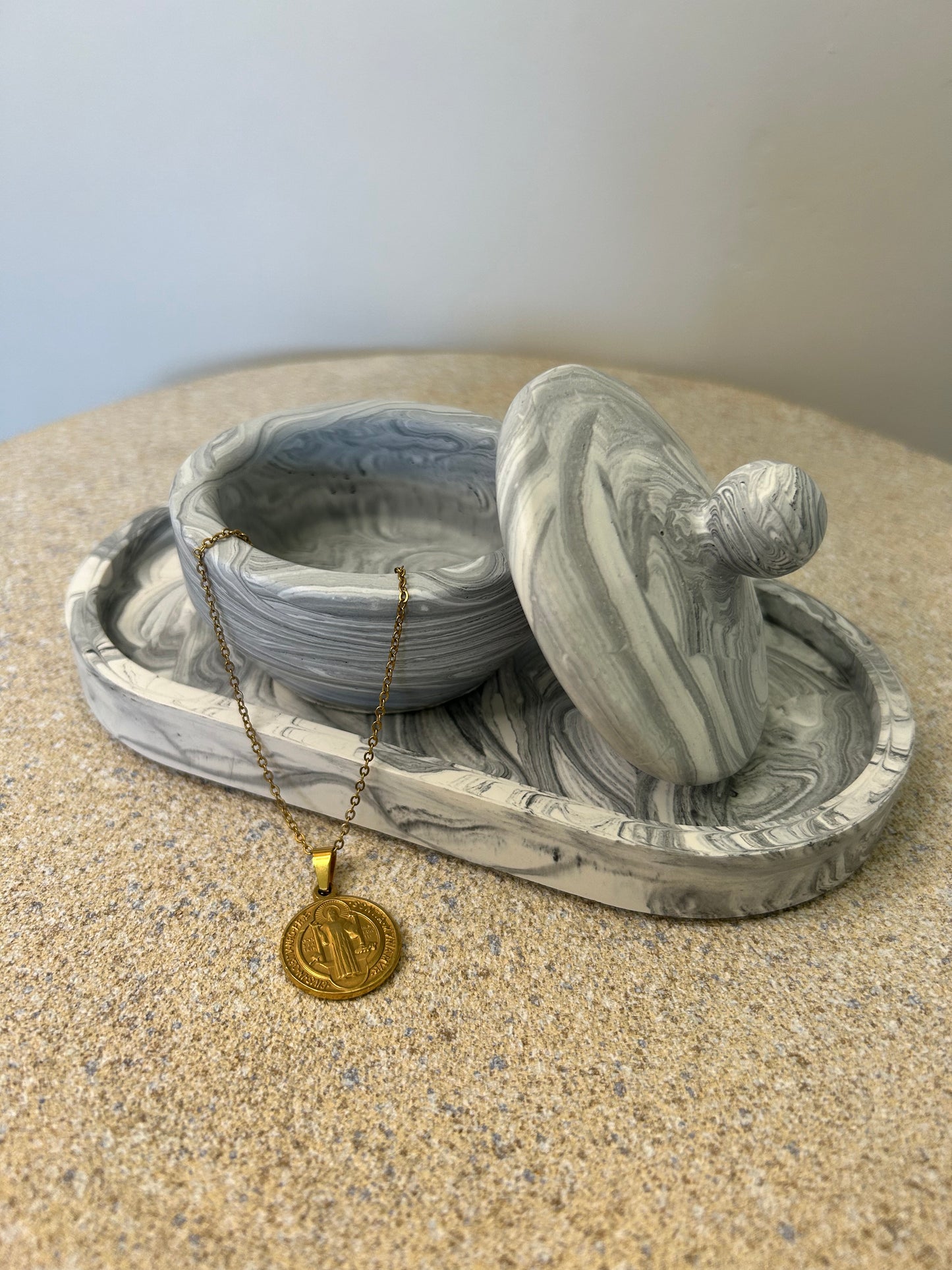 Handmade Home Accessories - a black marble trinket pot on a black marble trinket tray with a gold coin necklace hanging out the pot