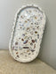 Handmade Home Accessories - an oval trinket tray with colour shifting oebbles that catch the light stood against a wall