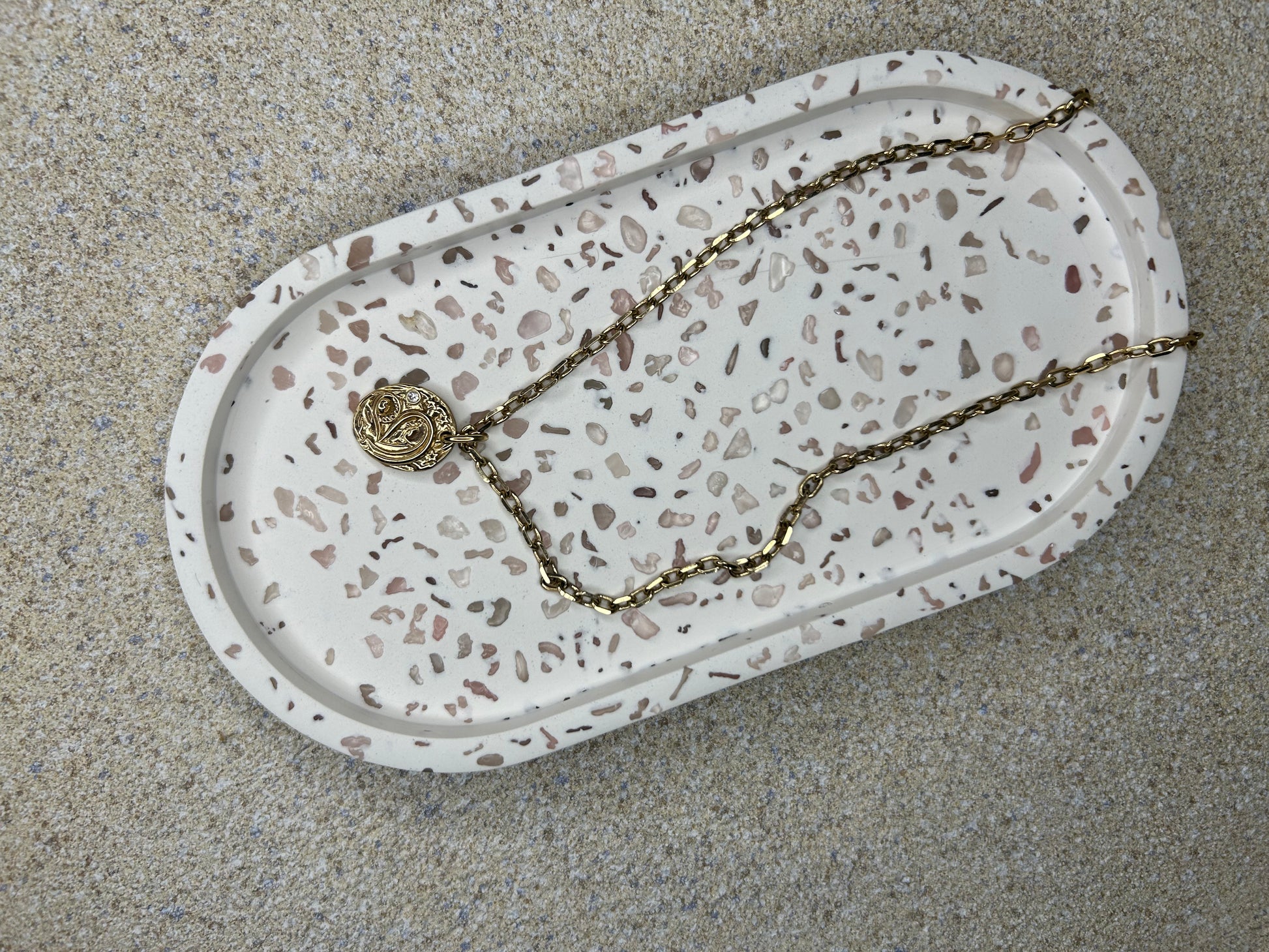 Handmade Home Accessories - a shot of a trinket tray with rose quartz used to create a terrazzo effect with a gold necklace on