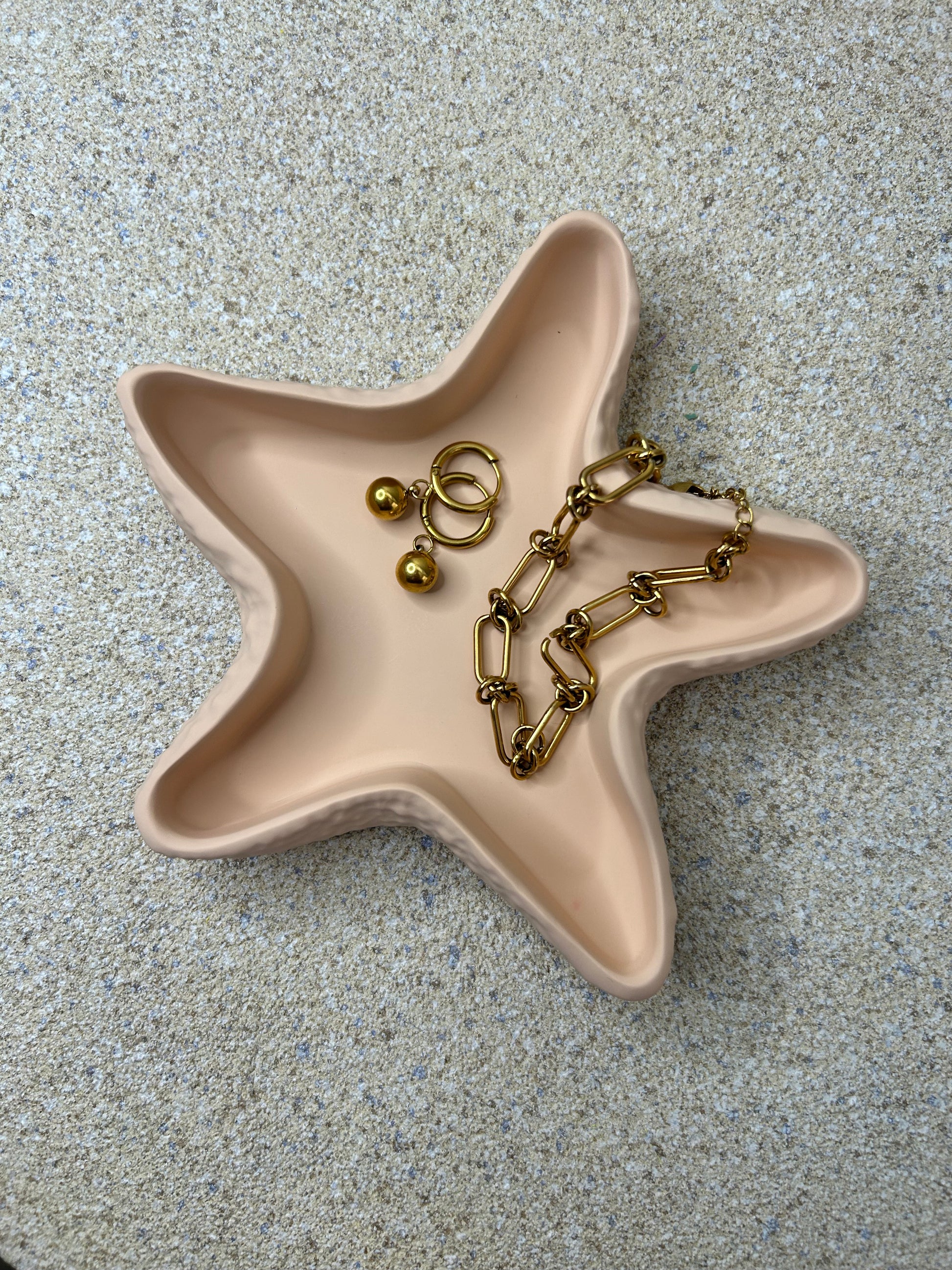 Handmade Home Accessories - a birds eye view shot of the peach starfish trinket dish with gold jewellery in