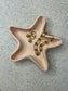 Handmade Home Accessories - a birds eye view shot of the peach starfish trinket dish with gold jewellery in