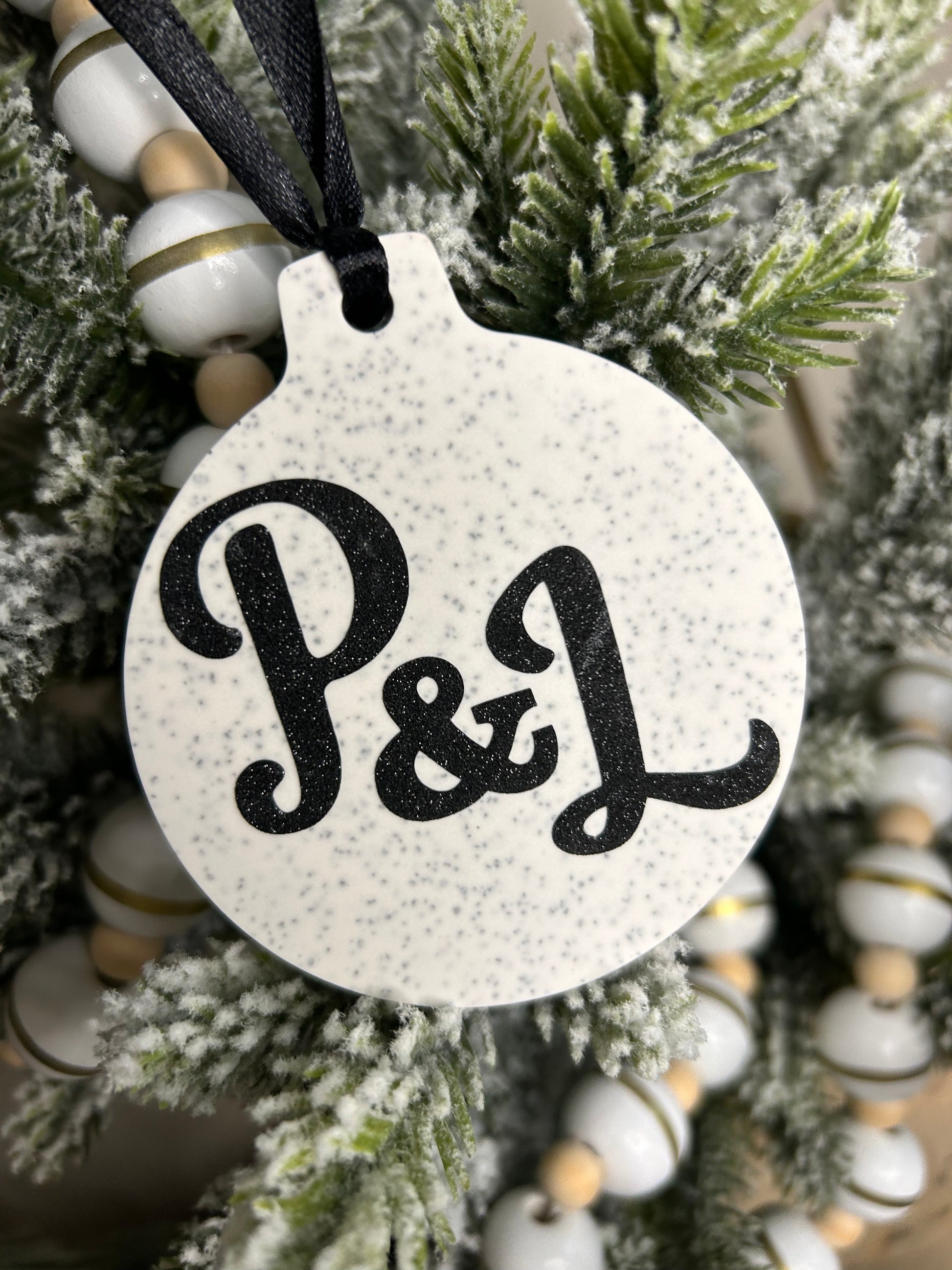 Handmade Christmas Decor - a close up shot of Sparkling initial hanging ornament with black P&L on.