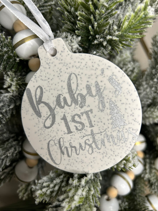 Handmade Christmas Decor- A close up shot of a baby's first Christmas bauble in silver shimmer writing.