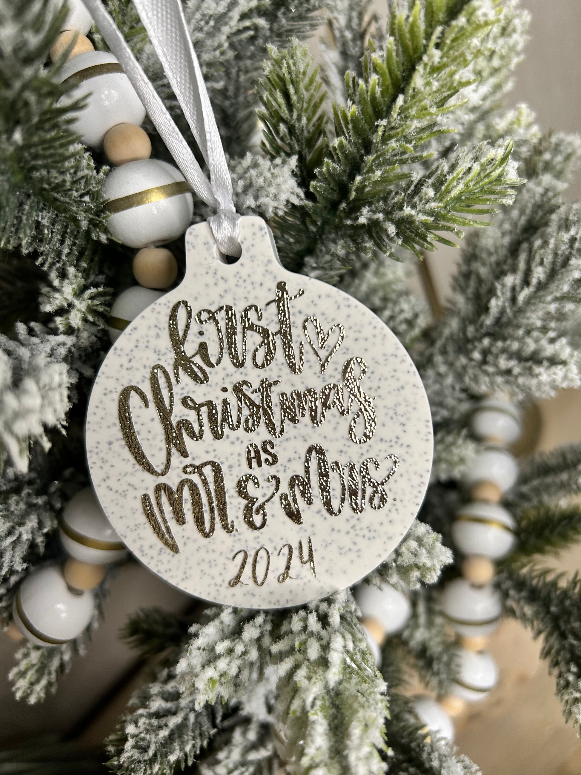 Handmade Christmas Decor - a close up shot of a neutral Christmas bauble with gold sparkling writing stating first Christmas as mr. and mrs.