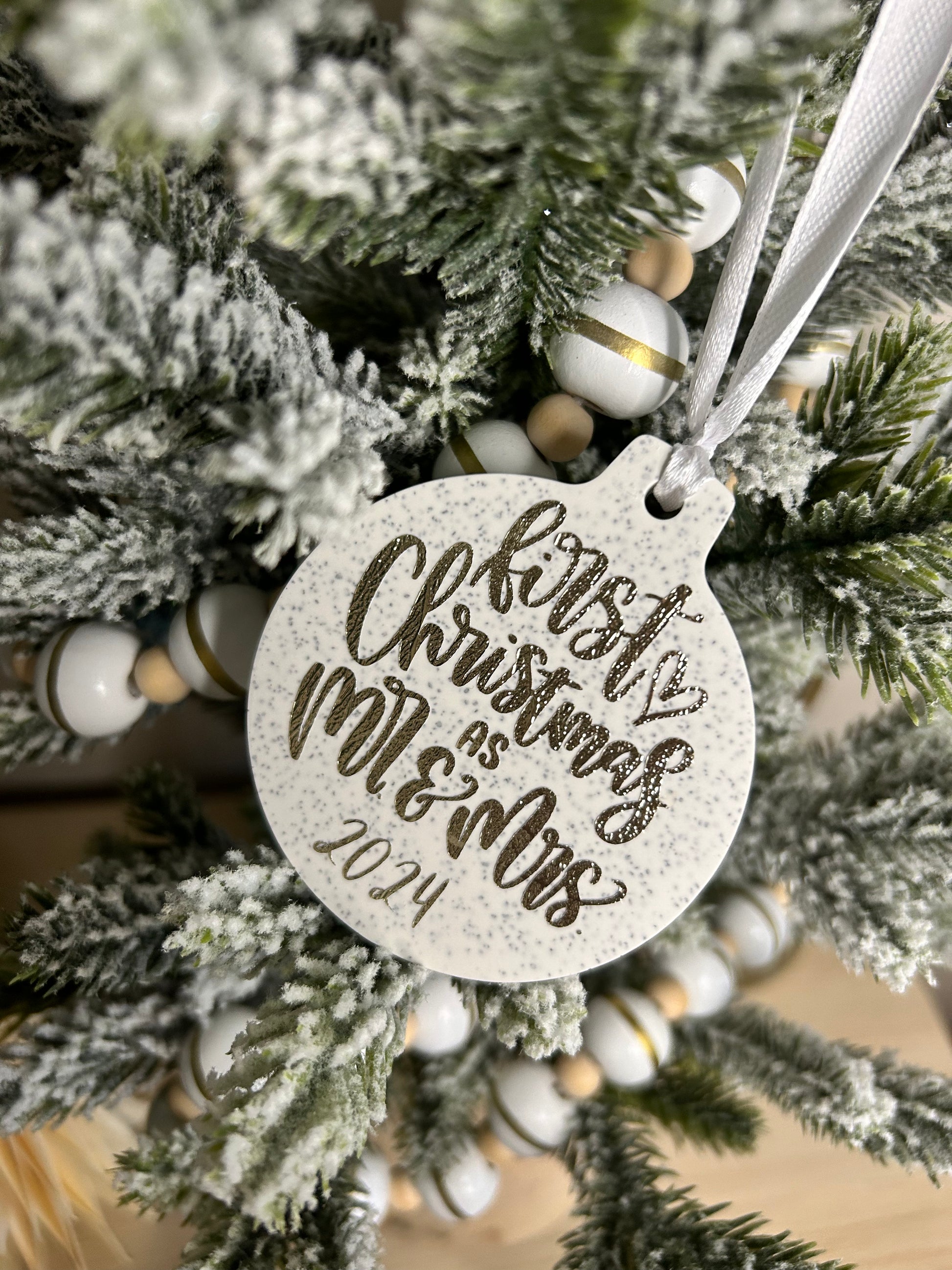 Handmade Christmas Decor - a neutral Christmas bauble with gold sparkling writing stating first Christmas as mr. and mrs.