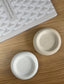 Top-down view of beige and white handmade Jesmonite trays with a raw stone-like finish. Eco-friendly home decor ideal for jewellery or desk styling.