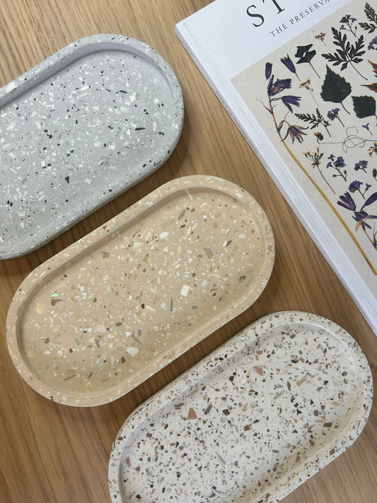 Set of three handmade terrazzo oval trays in neutral tones – minimalist Jesmonite accessories styled on natural wood.