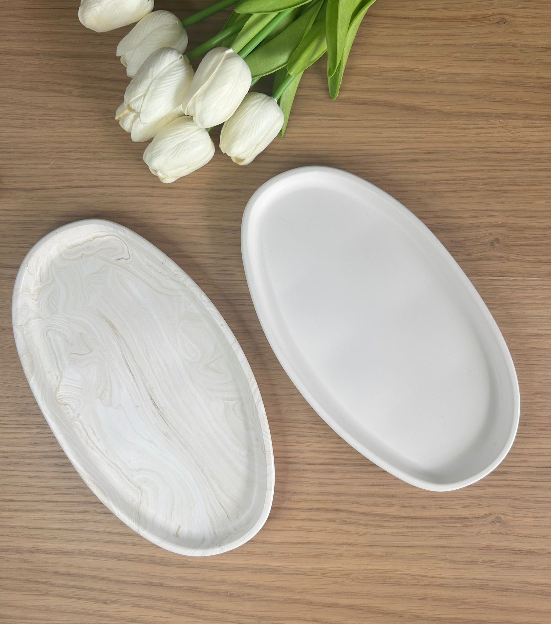 Set of white and marbled oval trinket dishes displayed with tulips, capturing the essence of handmade home accessories for modern interiors.