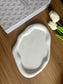 Single speckled Jesmonite tray with organic shape and soft matte finish, placed beside faux white tulips and a decorative journal – a minimalist handmade home accessory