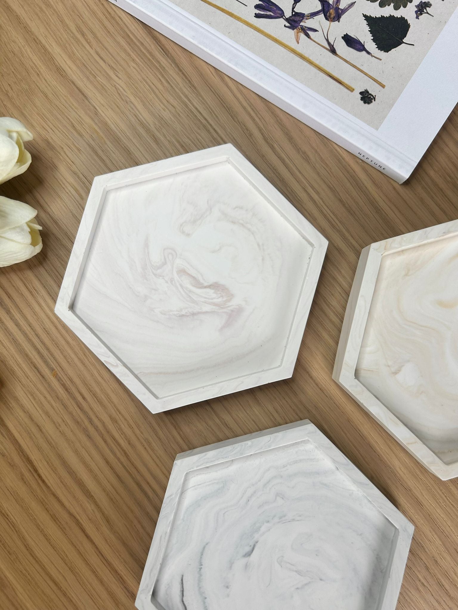 Flat lay of handmade Jesmonite hex trays in rose, cream and grey marbling. Sculptural, eco-friendly home accessories designed for everyday use.