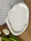 Handmade speckled Jesmonite tray with a natural cream base and black flecks, styled with white tulips and a patterned journal – a modern eco-friendly home accessory