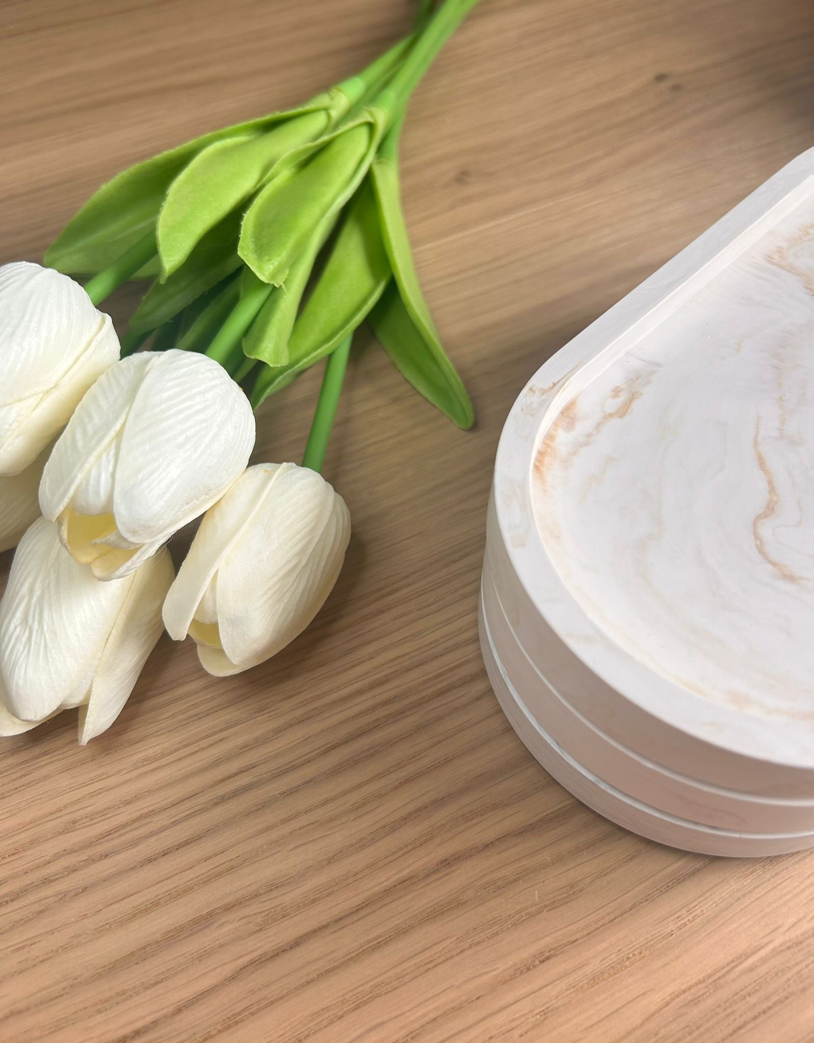 Stack of handmade Jesmonite trays with a soft marble finish, styled beside white tulips. A minimalist, eco-friendly home accessory perfect for gifting.