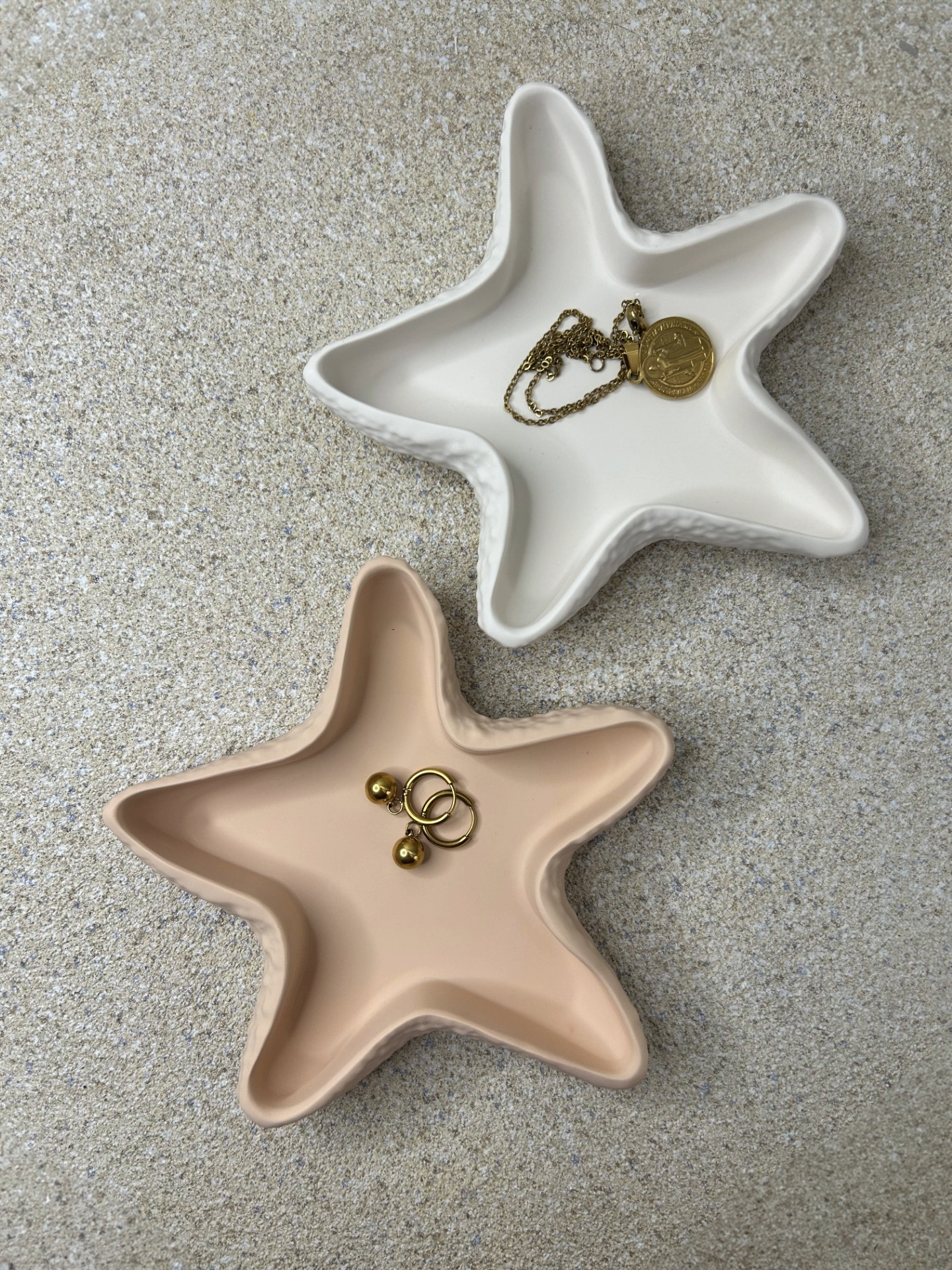 Handmade Home Accessories -  a birds eye view shot of the peach and off white starfish trinket dish with earrings and a gold necklace in